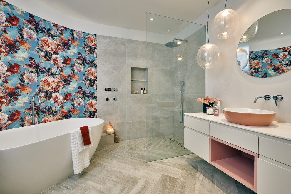 Design ideas for a contemporary wet room bathroom in London with flat-panel cabinets, beige cabinets, a freestanding bath, grey tiles, beige walls, a vessel sink, beige floors, an open shower and beige worktops.