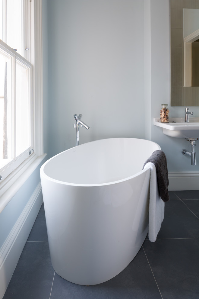 Idéer för små funkis en-suite badrum, med ett fristående badkar, grå kakel, porslinskakel, blå väggar, klinkergolv i porslin och ett väggmonterat handfat