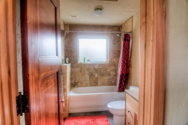 Idéer för ett mellanstort modernt vit badrum, med beige väggar, betonggolv, grått golv, släta luckor, skåp i mellenmörkt trä, ett fristående badkar, en dusch i en alkov, flerfärgad kakel, stenkakel, ett integrerad handfat och dusch med duschdraperi