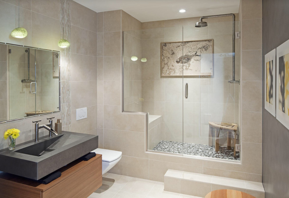 Klassisches Duschbad mit integriertem Waschbecken, flächenbündigen Schrankfronten, hellbraunen Holzschränken, Duschnische, Wandtoilette und beigen Fliesen in Sonstige