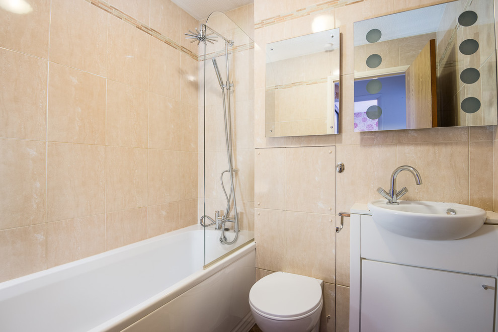 Idee per una piccola stanza da bagno per bambini design con vasca da incasso, vasca/doccia, WC sospeso, piastrelle beige e pareti beige