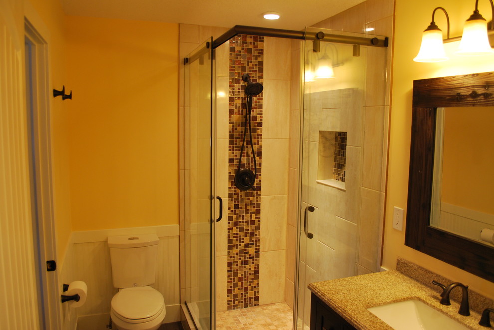 Пример оригинального дизайна: ванная комната среднего размера в стиле рустика с раздельным унитазом, разноцветной плиткой, каменной плиткой, желтыми стенами, фасадами в стиле шейкер, темными деревянными фасадами, отдельно стоящей ванной, угловым душем, темным паркетным полом, душевой кабиной, врезной раковиной, столешницей из известняка, коричневым полом и душем с раздвижными дверями