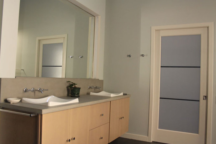 Photo of a medium sized modern ensuite bathroom in DC Metro with flat-panel cabinets, light wood cabinets, a built-in bath, a corner shower, grey walls, slate flooring, a vessel sink, concrete worktops, black floors and a hinged door.