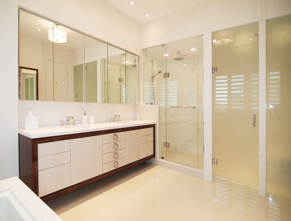 This is an example of a large contemporary ensuite bathroom in Toronto with light wood cabinets, quartz worktops, a freestanding bath, an alcove shower, a one-piece toilet, beige tiles, beige walls, flat-panel cabinets, marble tiles, porcelain flooring, a submerged sink, beige floors and a hinged door.