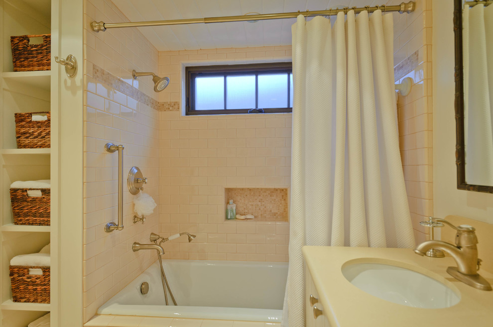 Idée de décoration pour une salle de bain principale marine de taille moyenne avec des portes de placard blanches, une baignoire posée, un combiné douche/baignoire, un carrelage rose, des carreaux de céramique, un mur blanc, un lavabo encastré, une cabine de douche avec un rideau, un plan de toilette beige, un placard à porte plane, un sol en calcaire, un plan de toilette en surface solide et un sol beige.