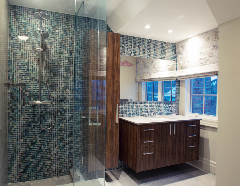 Design ideas for a large rustic ensuite bathroom in Toronto with flat-panel cabinets, medium wood cabinets, a one-piece toilet, blue tiles, mosaic tiles, beige walls, a submerged sink, engineered stone worktops, a corner shower and porcelain flooring.