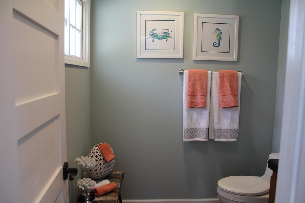 Example of a small beach style 3/4 bathroom design in Orange County with a one-piece toilet, gray walls, medium tone wood cabinets, solid surface countertops and black countertops