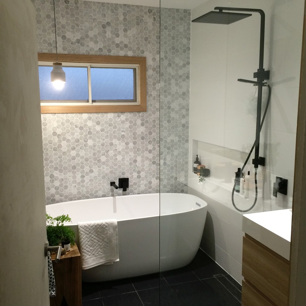 Design ideas for a small contemporary wet room bathroom in Brisbane with freestanding cabinets, brown cabinets, a freestanding bath, white tiles, ceramic tiles, multi-coloured walls, ceramic flooring, an integrated sink, solid surface worktops, black floors, an open shower and white worktops.