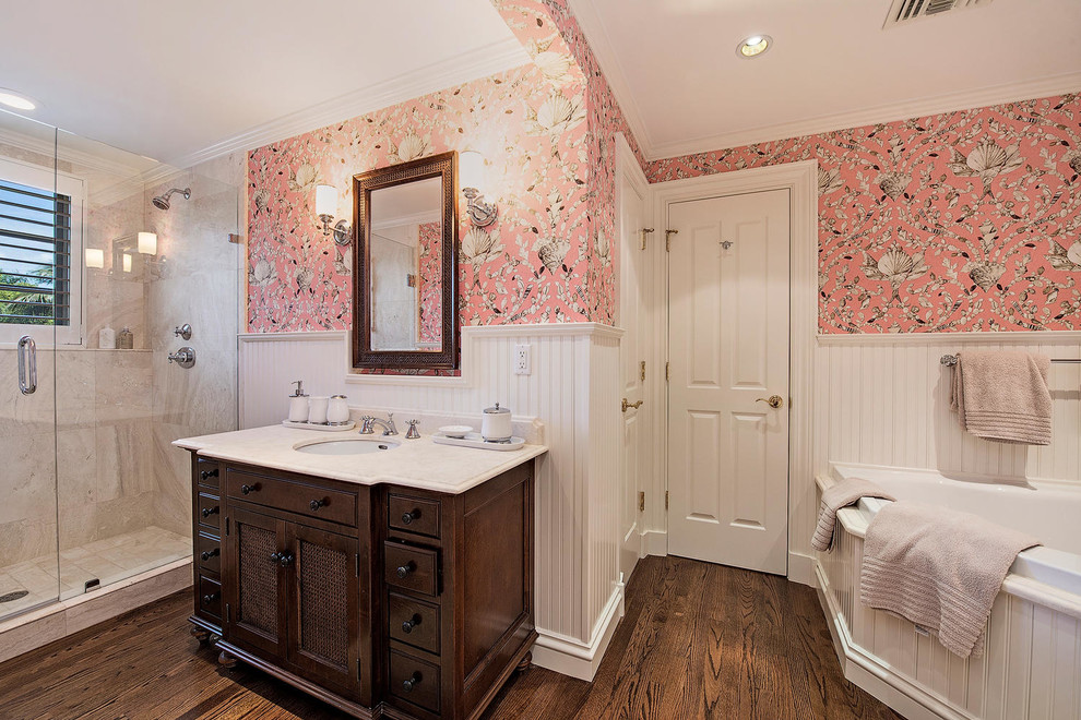 Идея дизайна: большая главная ванная комната в стиле неоклассика (современная классика) с фасадами островного типа, темными деревянными фасадами, душем в нише, раздельным унитазом, бежевой плиткой, каменной плиткой, розовыми стенами, темным паркетным полом, врезной раковиной и столешницей из кварцита