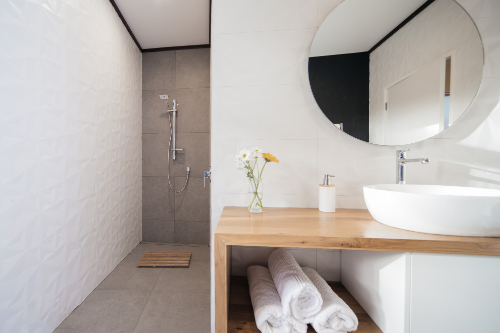 Bild på ett mellanstort funkis en-suite badrum, med skåp i mellenmörkt trä, en hörndusch, en toalettstol med hel cisternkåpa, vit kakel, keramikplattor, vita väggar, klinkergolv i keramik, brunt golv och med dusch som är öppen