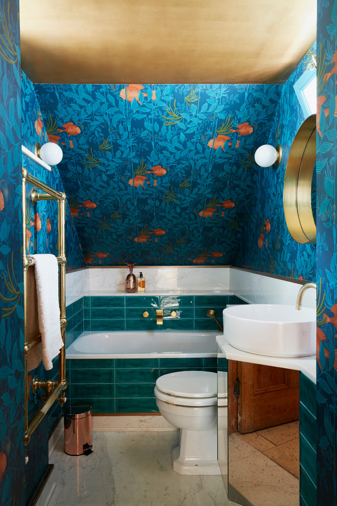 Idée de décoration pour une petite salle de bain bohème pour enfant avec un mur bleu, un sol en marbre, un placard à porte vitrée, une baignoire posée, WC à poser, un carrelage vert, des carreaux de céramique, un plan vasque et un plan de toilette en marbre.