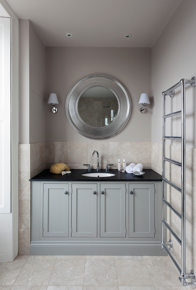 Cette photo montre une salle de bain chic avec un lavabo encastré, un placard à porte shaker, des portes de placard grises, un carrelage beige et un mur gris.