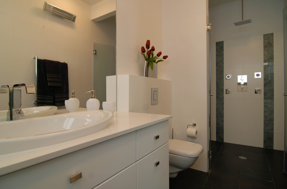 Maritimes Badezimmer mit Aufsatzwaschbecken, flächenbündigen Schrankfronten, weißen Schränken, Wandtoilette und weißen Fliesen in Sonstige