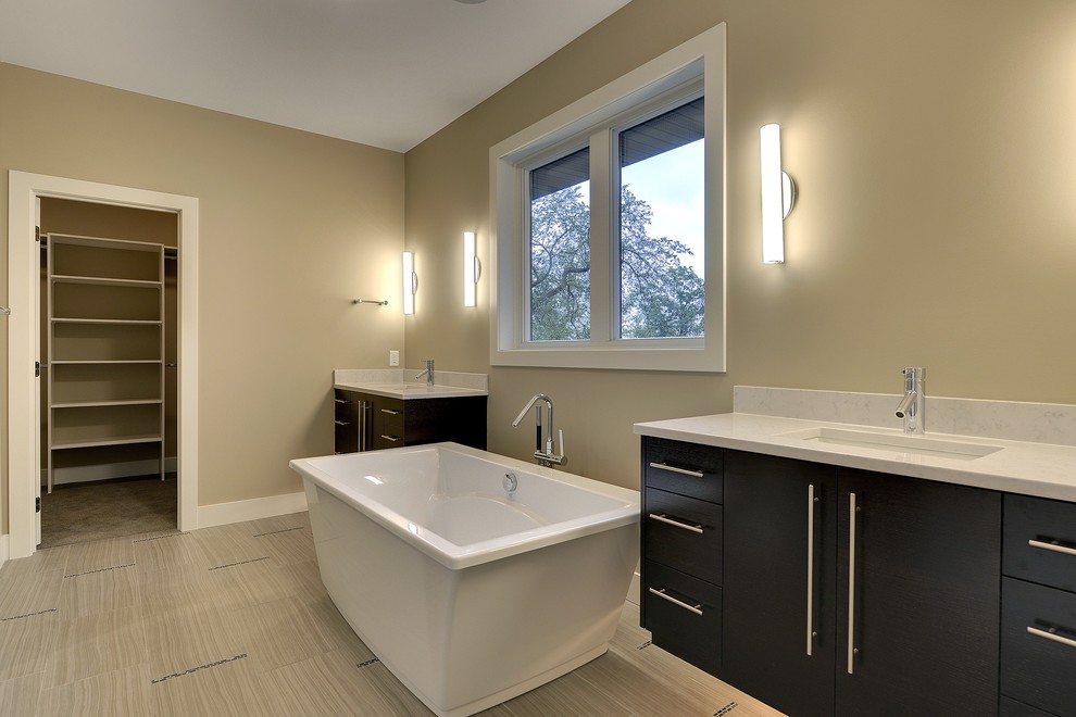 Photo of a large classic ensuite bathroom in Minneapolis with a submerged sink, flat-panel cabinets, black cabinets, marble worktops, a freestanding bath, a double shower, a one-piece toilet, brown tiles, porcelain tiles, beige walls and porcelain flooring.