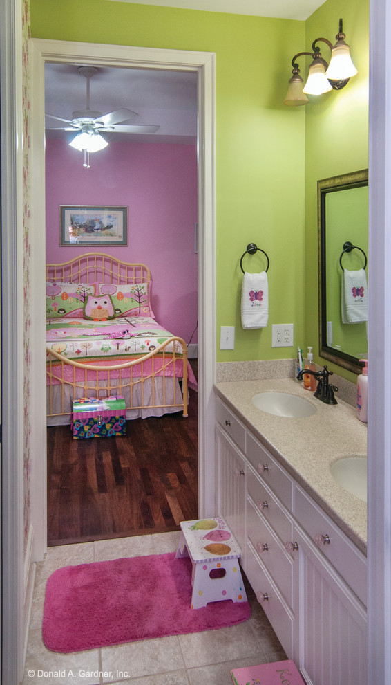 Modelo de cuarto de baño infantil de estilo americano de tamaño medio con lavabo bajoencimera, armarios con rebordes decorativos, puertas de armario blancas, baldosas y/o azulejos beige y paredes verdes