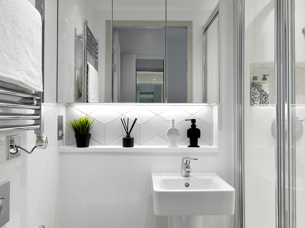 Свежая идея для дизайна: ванная комната в современном стиле с угловым душем, белой плиткой, белыми стенами, душевой кабиной и подвесной раковиной - отличное фото интерьера