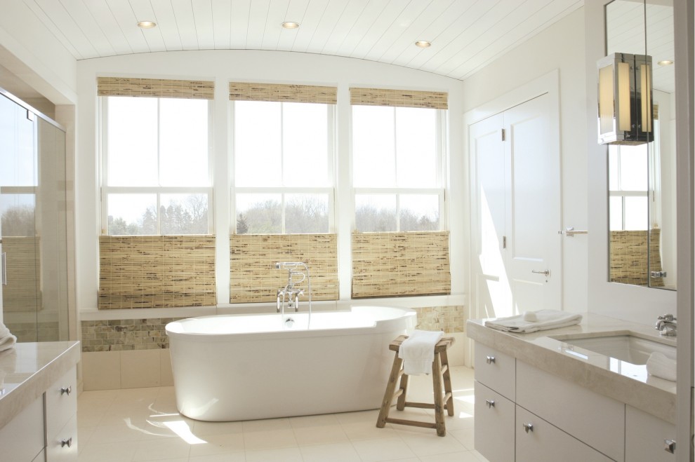 На фото: ванная комната: освещение в морском стиле с отдельно стоящей ванной с
