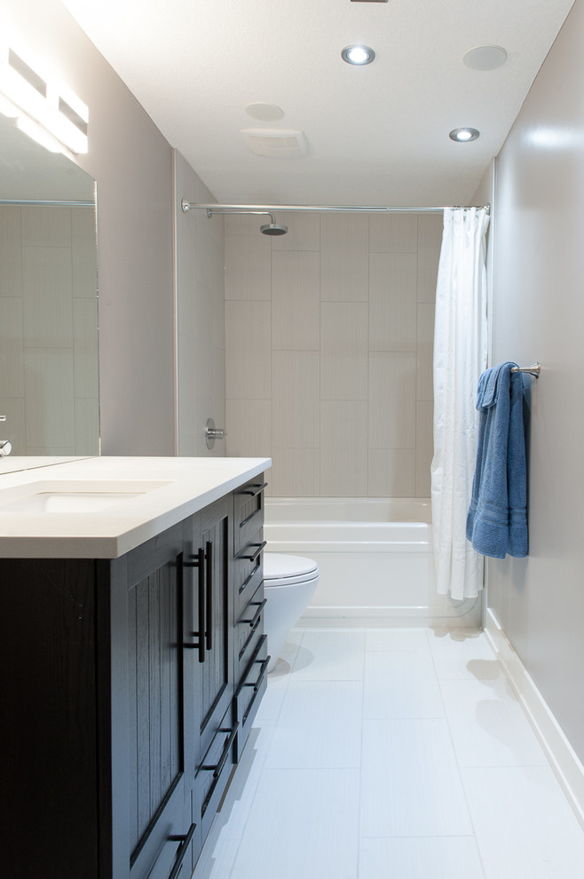 Cette photo montre une salle de bain tendance en bois foncé de taille moyenne avec un placard à porte persienne, une baignoire en alcôve, un combiné douche/baignoire, WC séparés, un mur gris, un sol en carrelage de céramique et un lavabo encastré.