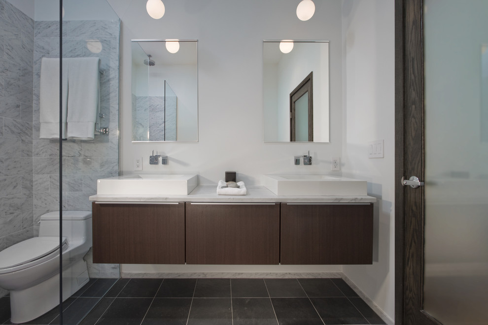 This is an example of a medium sized contemporary ensuite bathroom in Minneapolis with a vessel sink, flat-panel cabinets, medium wood cabinets, marble worktops, a freestanding bath, a built-in shower, a one-piece toilet, grey tiles, stone tiles and slate flooring.