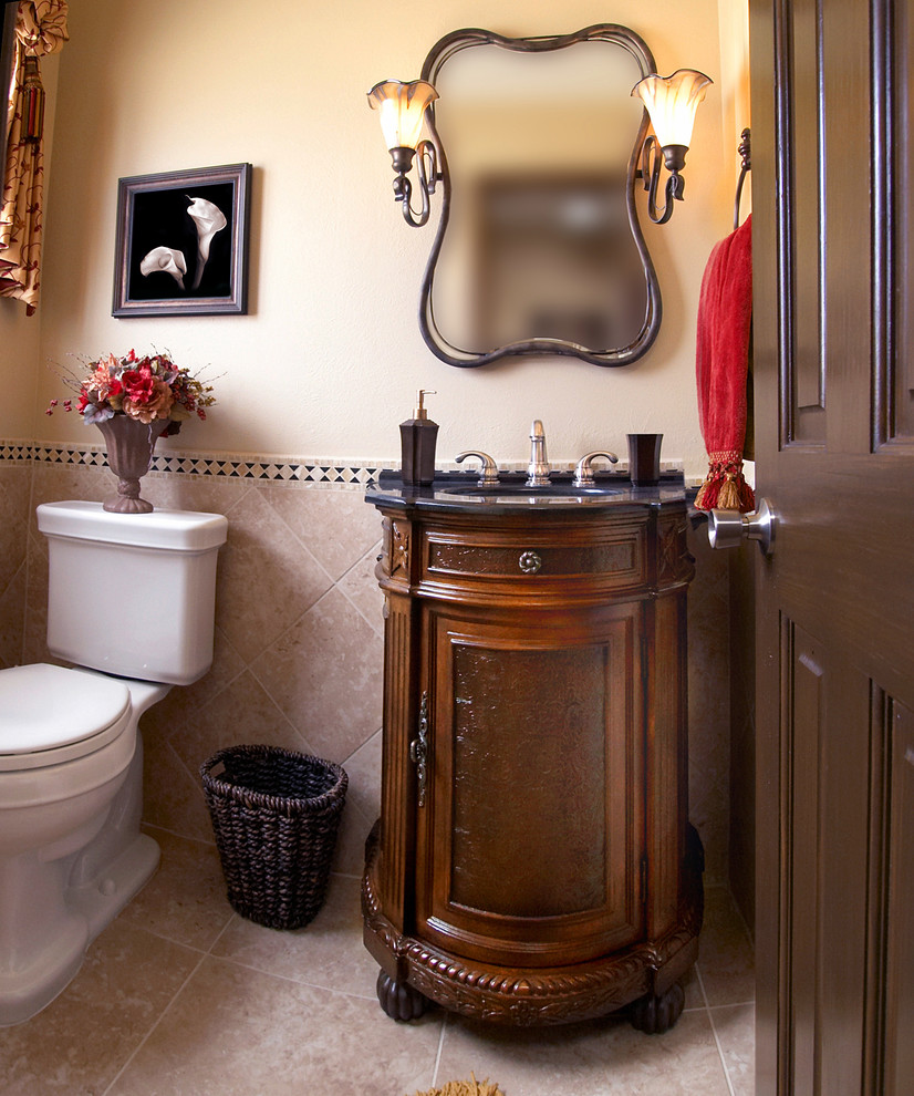 Photo of a small traditional shower room bathroom in Albuquerque with freestanding cabinets, medium wood cabinets, a one-piece toilet, stone tiles, beige walls, vinyl flooring, a submerged sink, granite worktops, beige floors and black worktops.