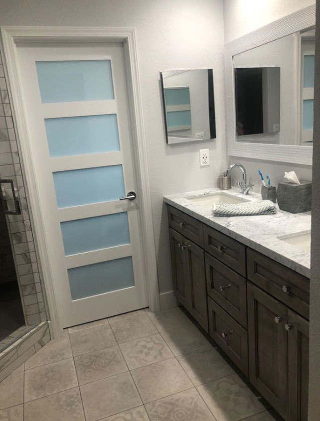 Foto på ett litet vit en-suite badrum, med skåp i shakerstil, bruna skåp, en hörndusch, grå kakel, vita väggar, bänkskiva i kvartsit och dusch med gångjärnsdörr