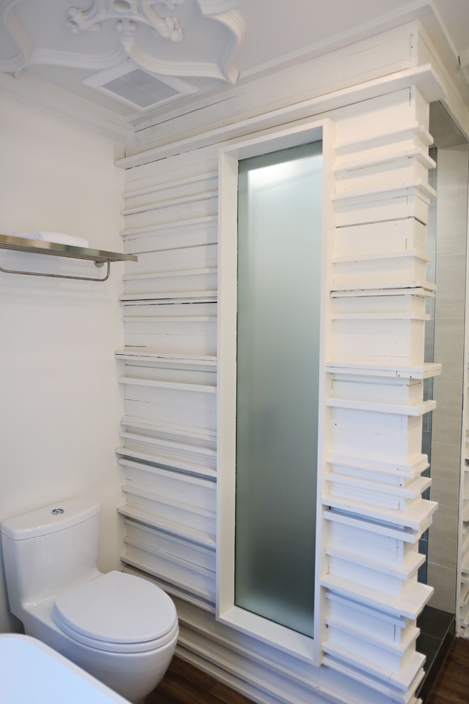 Bild på ett mellanstort vintage en-suite badrum, med ett fristående handfat, möbel-liknande, skåp i mörkt trä, granitbänkskiva, ett fristående badkar, en hörndusch, en toalettstol med hel cisternkåpa, grå kakel, porslinskakel, vita väggar och vinylgolv
