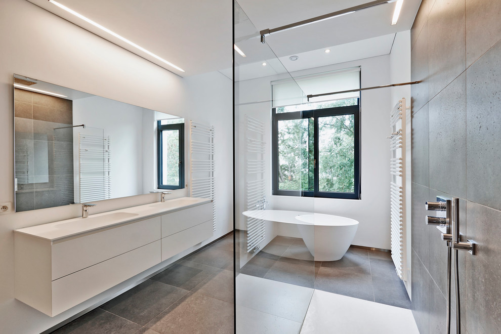 Réalisation d'une salle de bain principale design de taille moyenne avec un placard à porte plane, des portes de placard beiges, une baignoire indépendante, un espace douche bain, un mur beige, un lavabo encastré et un sol en ardoise.