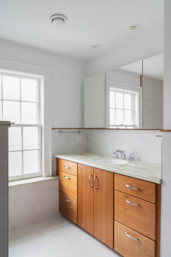 Inspiration for a mid-sized contemporary 3/4 white tile and porcelain tile porcelain tile and white floor bathroom remodel in Boston with an urinal, white walls, an integrated sink, solid surface countertops and green countertops