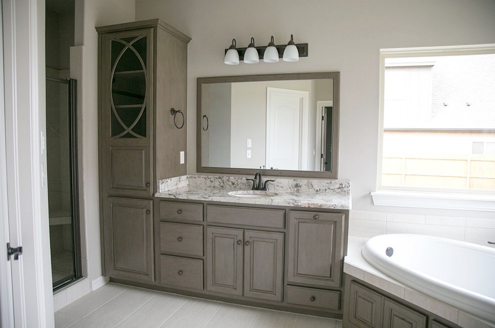 Inredning av ett klassiskt stort en-suite badrum, med luckor med upphöjd panel, grå skåp, ett platsbyggt badkar, en dusch i en alkov, vit kakel, keramikplattor, beige väggar, klinkergolv i keramik, ett undermonterad handfat och marmorbänkskiva