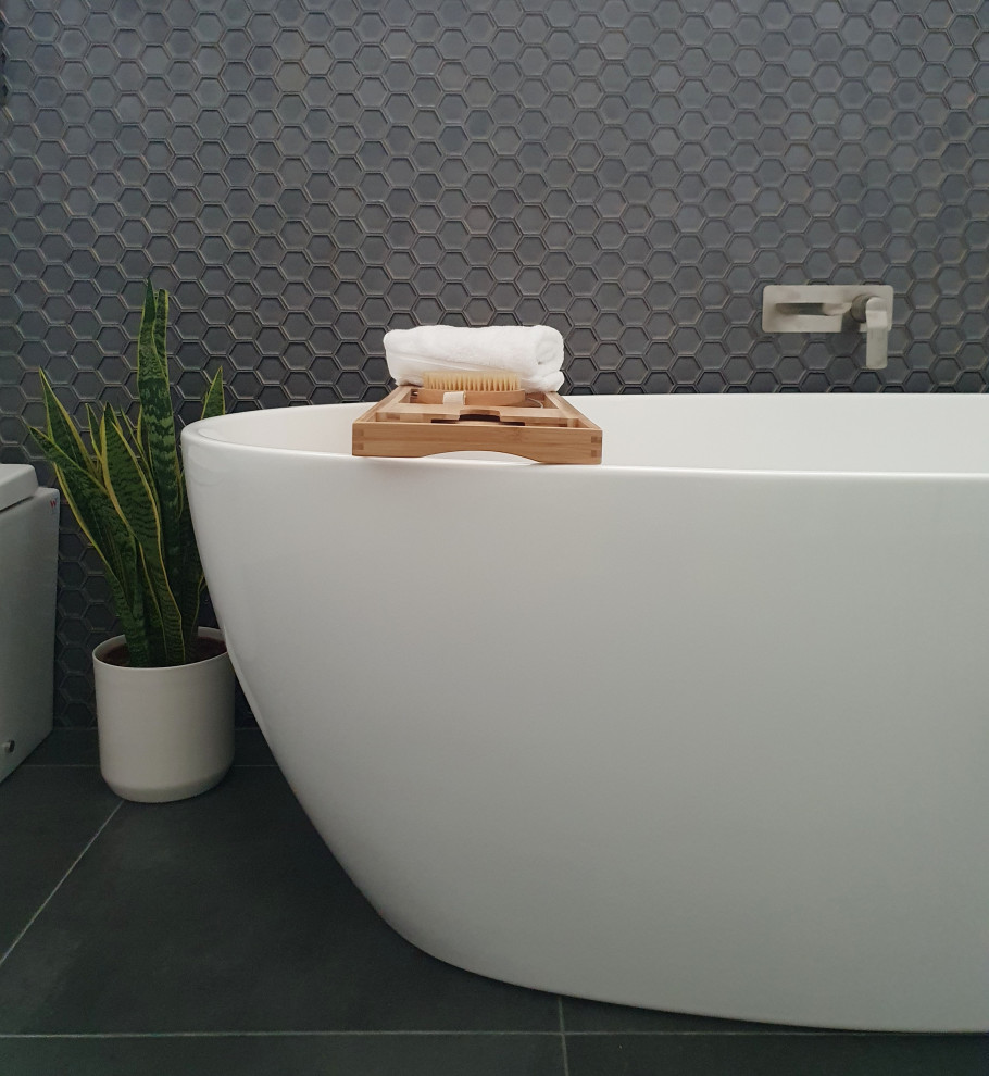Esempio di una stanza da bagno minimalista con ante bianche, vasca freestanding, doccia aperta, piastrelle a mosaico, doccia aperta, due lavabi e mobile bagno sospeso