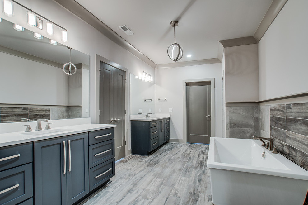 Inspiration för stora klassiska en-suite badrum, med luckor med infälld panel, blå skåp, ett fristående badkar, grå kakel, stenkakel, vita väggar, ljust trägolv, ett undermonterad handfat, bänkskiva i kvarts, grått golv, en öppen dusch och med dusch som är öppen