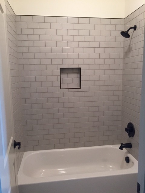 На фото: ванная комната в стиле неоклассика (современная классика) с ванной в нише, душем над ванной, белой плиткой, плиткой кабанчик, белыми стенами и шторкой для ванной с