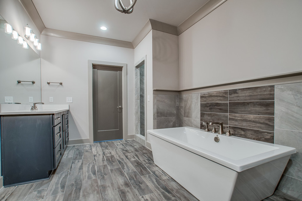 Bild på ett stort vintage en-suite badrum, med luckor med infälld panel, blå skåp, ett fristående badkar, grå kakel, stenkakel, vita väggar, ljust trägolv, ett undermonterad handfat, bänkskiva i kvarts, grått golv, en öppen dusch och med dusch som är öppen