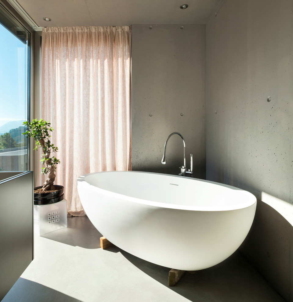 Diseño de cuarto de baño actual con bañera exenta y paredes grises