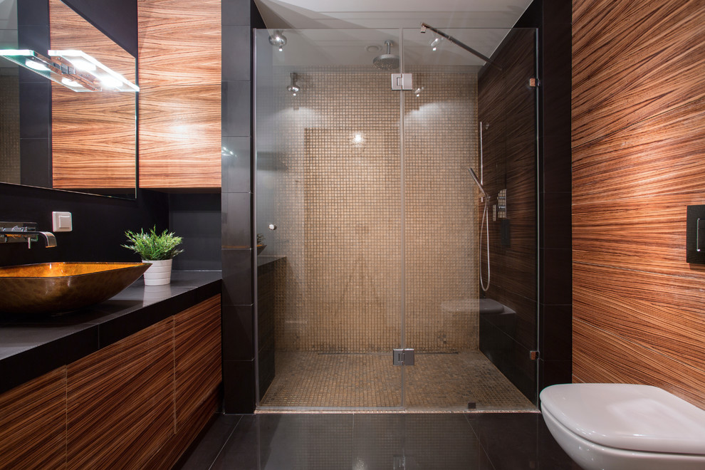 Modelo de cuarto de baño actual con lavabo sobreencimera, ducha a ras de suelo y sanitario de pared