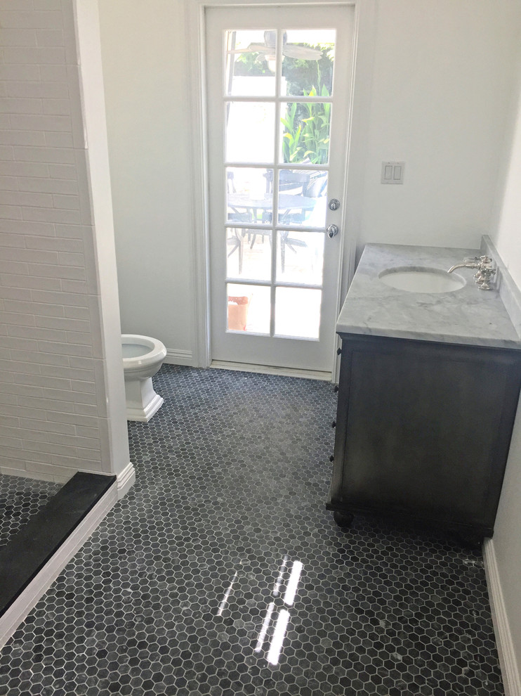 Cette image montre une salle de bain vintage en bois foncé de taille moyenne avec un mur blanc, un sol en ardoise, un lavabo encastré, un plan de toilette en marbre, un sol noir et un plan de toilette gris.
