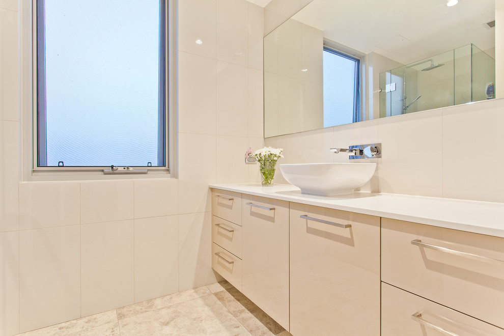 На фото: ванная комната в современном стиле с настольной раковиной, плоскими фасадами, бежевыми фасадами, бежевой плиткой и бежевым полом