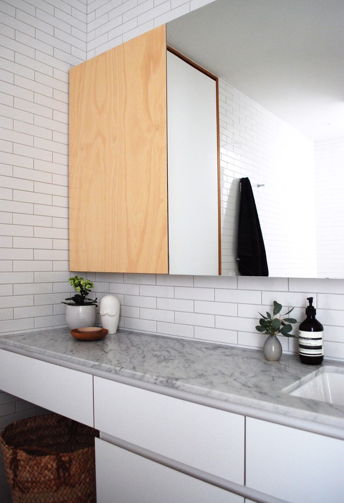 Inspiration för mellanstora moderna en-suite badrum, med ett undermonterad handfat, skåp i ljust trä, marmorbänkskiva, vit kakel, tunnelbanekakel, vita väggar och klinkergolv i keramik