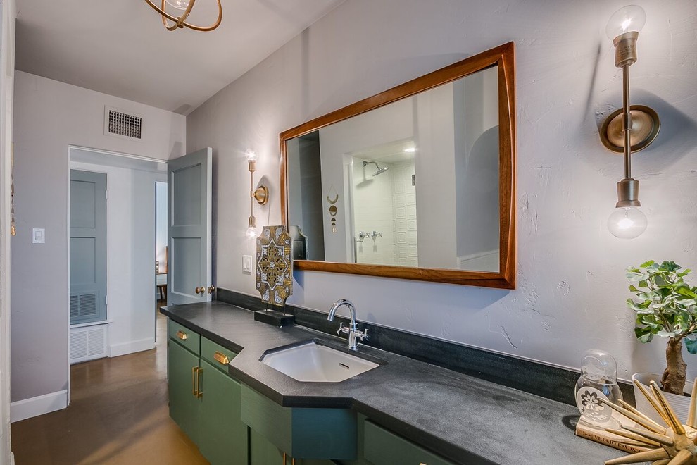Réalisation d'une salle de bain tradition de taille moyenne avec un placard à porte plane, des portes de placards vertess, un mur gris, sol en béton ciré, un lavabo encastré et un sol marron.