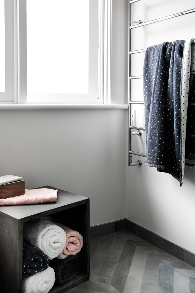 Réalisation d'une salle de bain design de taille moyenne avec des portes de placard blanches, une douche d'angle, WC à poser, un carrelage gris, des carreaux de porcelaine, un mur blanc, un sol en carrelage de porcelaine, un lavabo intégré et un plan de toilette en surface solide.