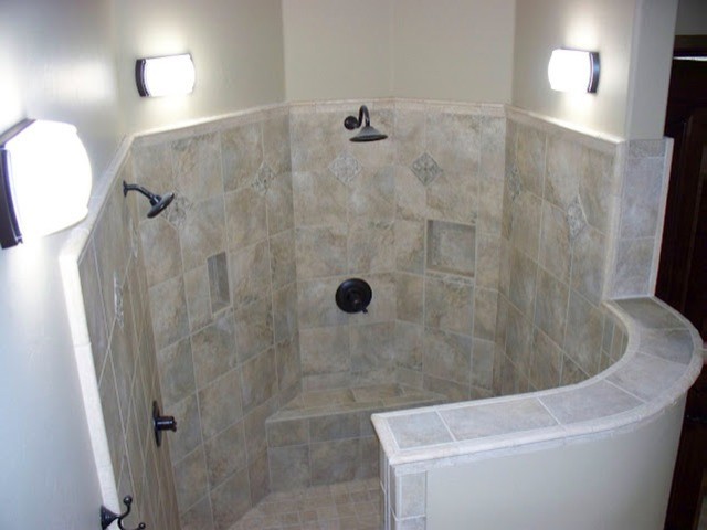 Klassisk inredning av ett stort en-suite badrum, med luckor med infälld panel, skåp i mellenmörkt trä, granitbänkskiva, en jacuzzi, en hörndusch, beige kakel, keramikplattor, beige väggar och klinkergolv i keramik