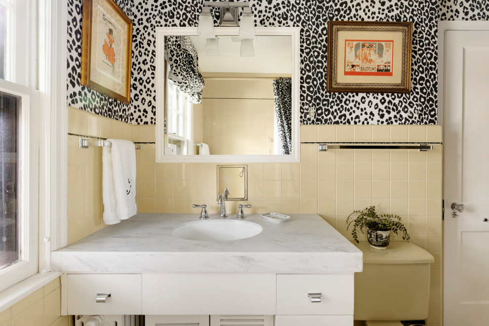 На фото: маленькая главная ванная комната в стиле фьюжн с плоскими фасадами, белыми фасадами, ванной в нише, душем над ванной, раздельным унитазом, желтой плиткой, керамической плиткой, врезной раковиной, мраморной столешницей, желтым полом, белой столешницей, тумбой под одну раковину, встроенной тумбой и обоями на стенах для на участке и в саду с
