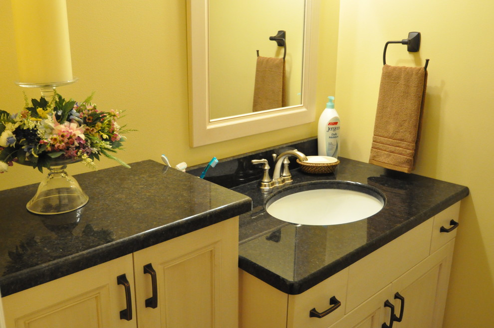 Imagen de cuarto de baño tradicional renovado con lavabo bajoencimera, armarios con paneles lisos, bañera empotrada y baldosas y/o azulejos de porcelana