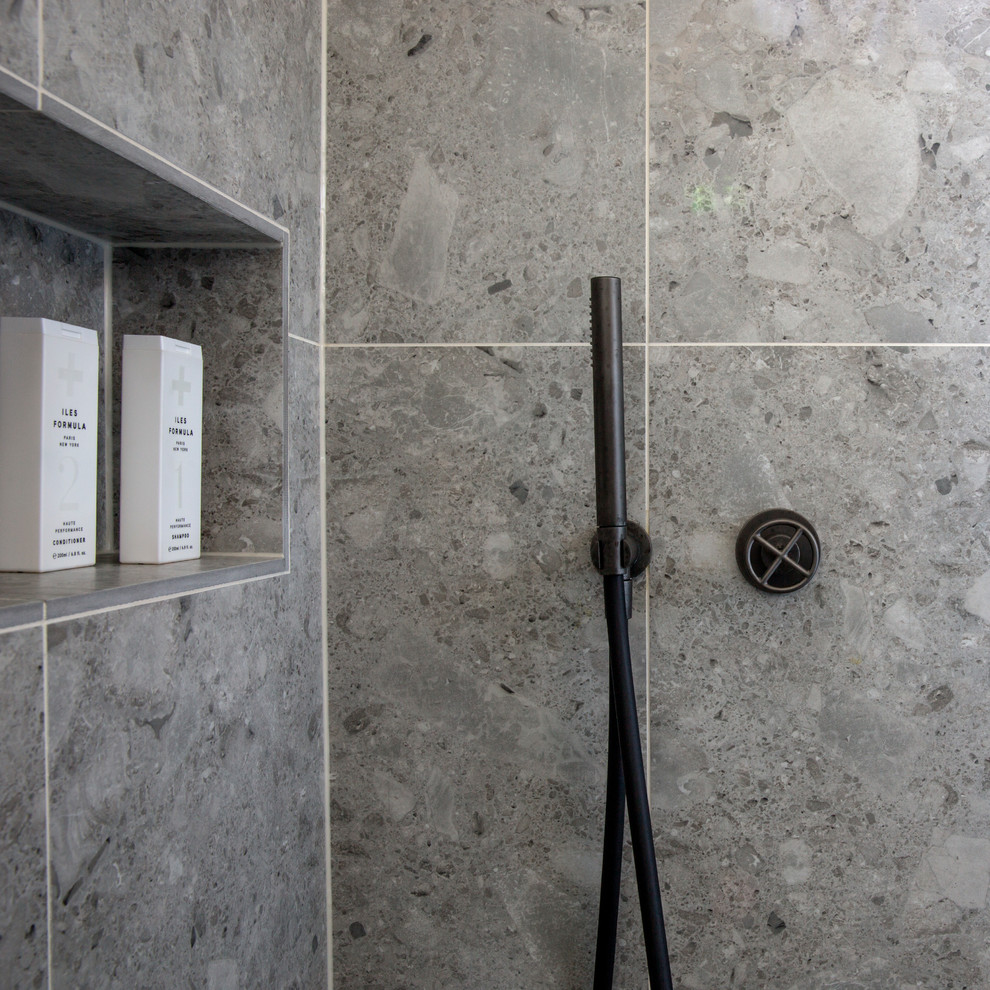 Idéer för att renovera ett litet skandinaviskt grå grått en-suite badrum, med öppna hyllor, grå skåp, ett fristående badkar, en öppen dusch, en vägghängd toalettstol, grå kakel, kakelplattor, blå väggar, terrazzogolv, ett undermonterad handfat, marmorbänkskiva, grått golv och dusch med gångjärnsdörr