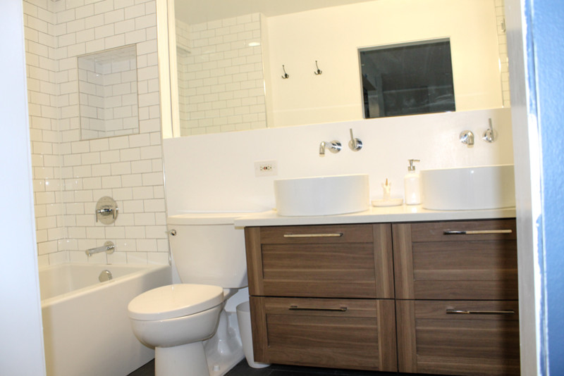 Bild på ett mellanstort funkis en-suite badrum, med skåp i shakerstil, bruna skåp, en toalettstol med separat cisternkåpa, svart och vit kakel, tunnelbanekakel, vita väggar, marmorgolv och ett integrerad handfat