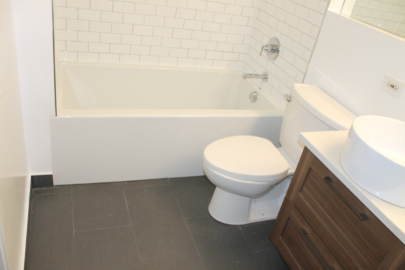 Mid-sized minimalist master black and white tile and subway tile marble floor bathroom photo in Chicago with shaker cabinets, brown cabinets, a two-piece toilet, white walls and an integrated sink