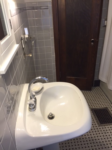 Idéer för att renovera ett mellanstort vintage en-suite badrum, med ett piedestal handfat, släta luckor, vita skåp, ett fristående badkar, en dusch/badkar-kombination, en toalettstol med hel cisternkåpa, grå kakel, porslinskakel, vita väggar och klinkergolv i porslin