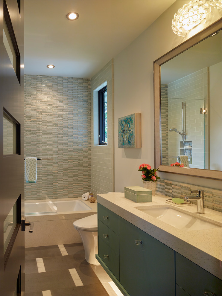 Idée de décoration pour une salle de bain design de taille moyenne avec un placard à porte plane, des portes de placard turquoises, une baignoire encastrée, un combiné douche/baignoire, WC à poser, un carrelage bleu, mosaïque, un mur gris, un sol en carrelage de porcelaine, un lavabo encastré, un plan de toilette en quartz modifié, un sol gris et une cabine de douche à porte battante.