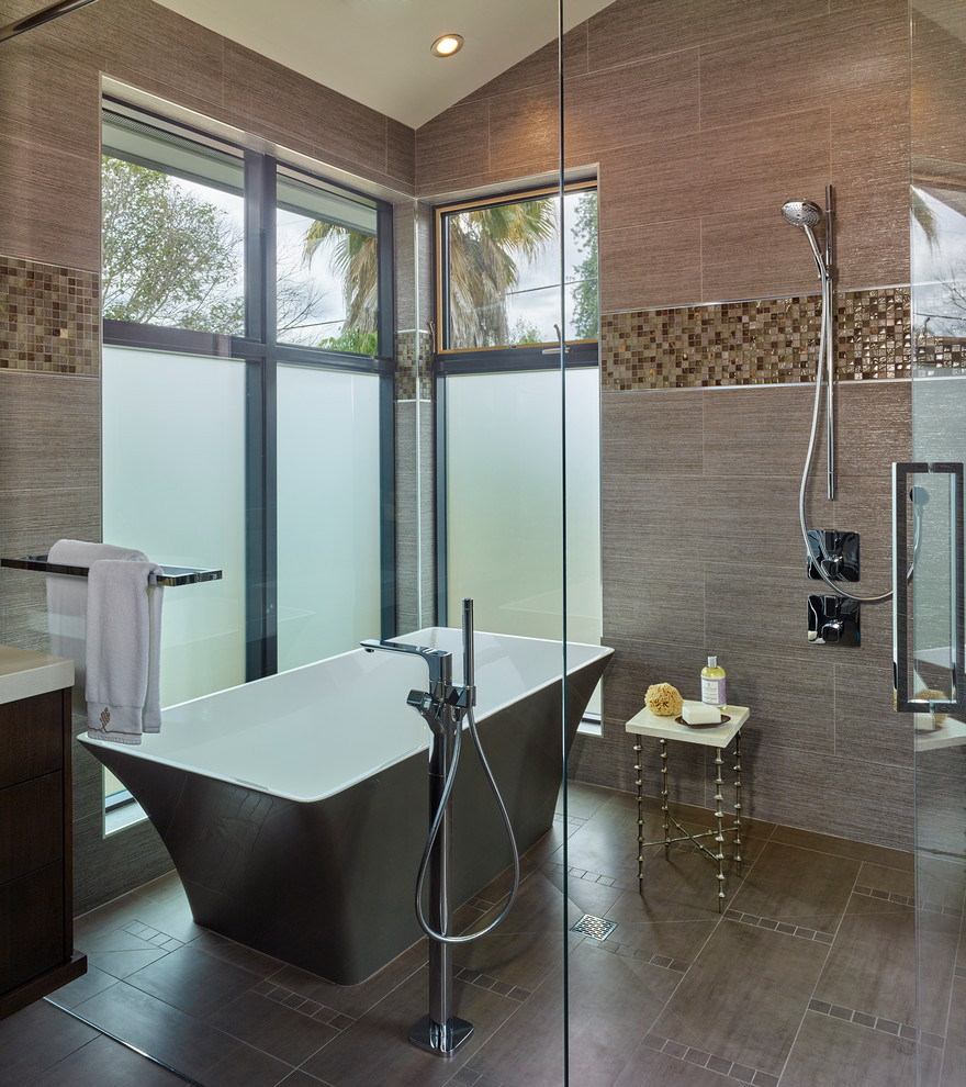 Inspiration for a large contemporary ensuite wet room bathroom in San Francisco with flat-panel cabinets, dark wood cabinets, a freestanding bath, a one-piece toilet, grey tiles, mosaic tiles, grey walls, porcelain flooring, a submerged sink, engineered stone worktops, grey floors and a hinged door.