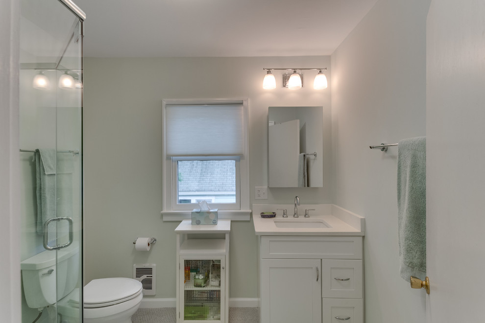 Идея дизайна: ванная комната среднего размера в современном стиле с фасадами островного типа, белыми фасадами, угловым душем, раздельным унитазом, серой плиткой, зеленой плиткой, стеклянной плиткой, зелеными стенами, душевой кабиной, врезной раковиной, столешницей из искусственного камня, бежевым полом и душем с распашными дверями